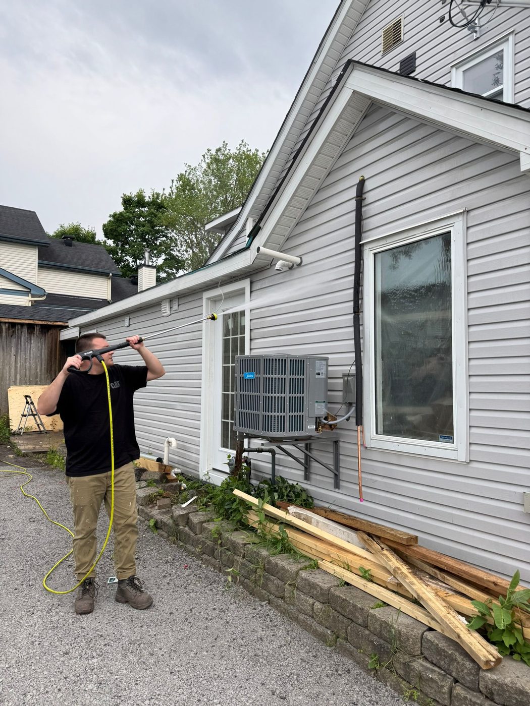 Setting up to spray-paint a grey home exterior