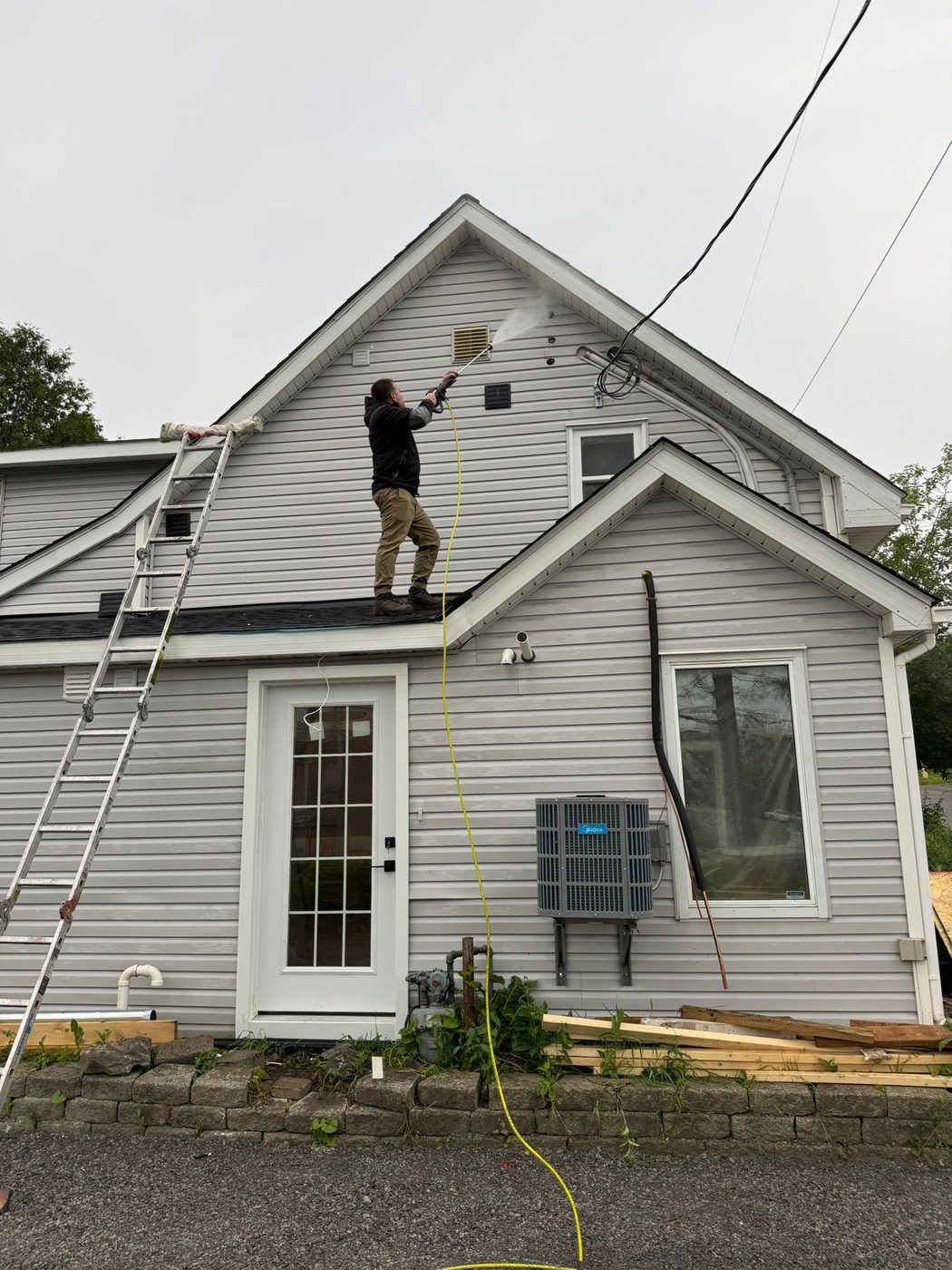 Painting the upper siding of a home from the porch roof